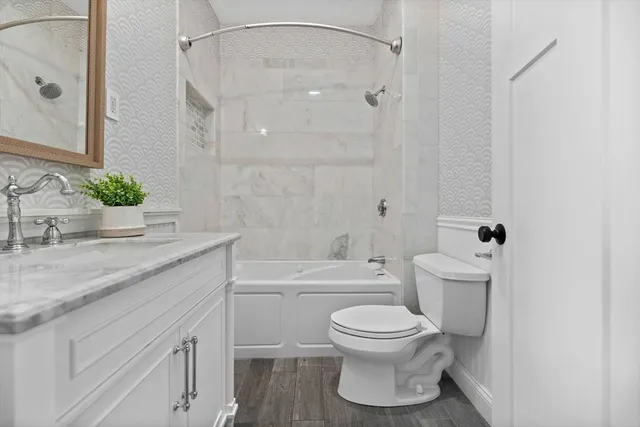 a bathroom with a granite countertop toilet sink and shower