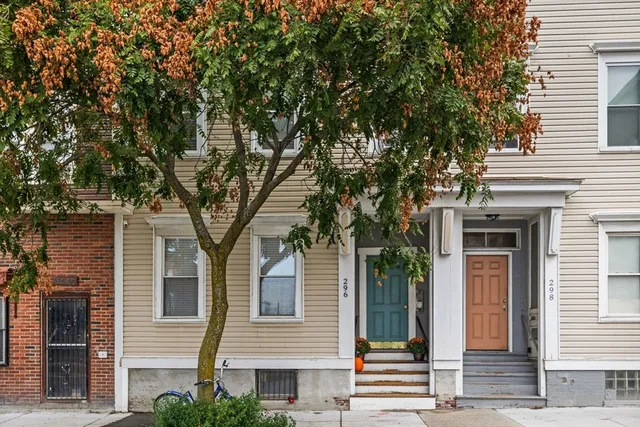 a front view of a house with a tree