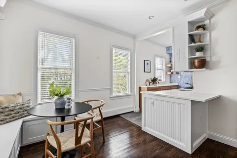 a kitchen with a table chairs and a window