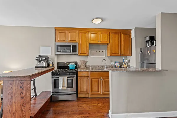 a kitchen with stainless steel appliances granite countertop a stove a sink and a refrigerator