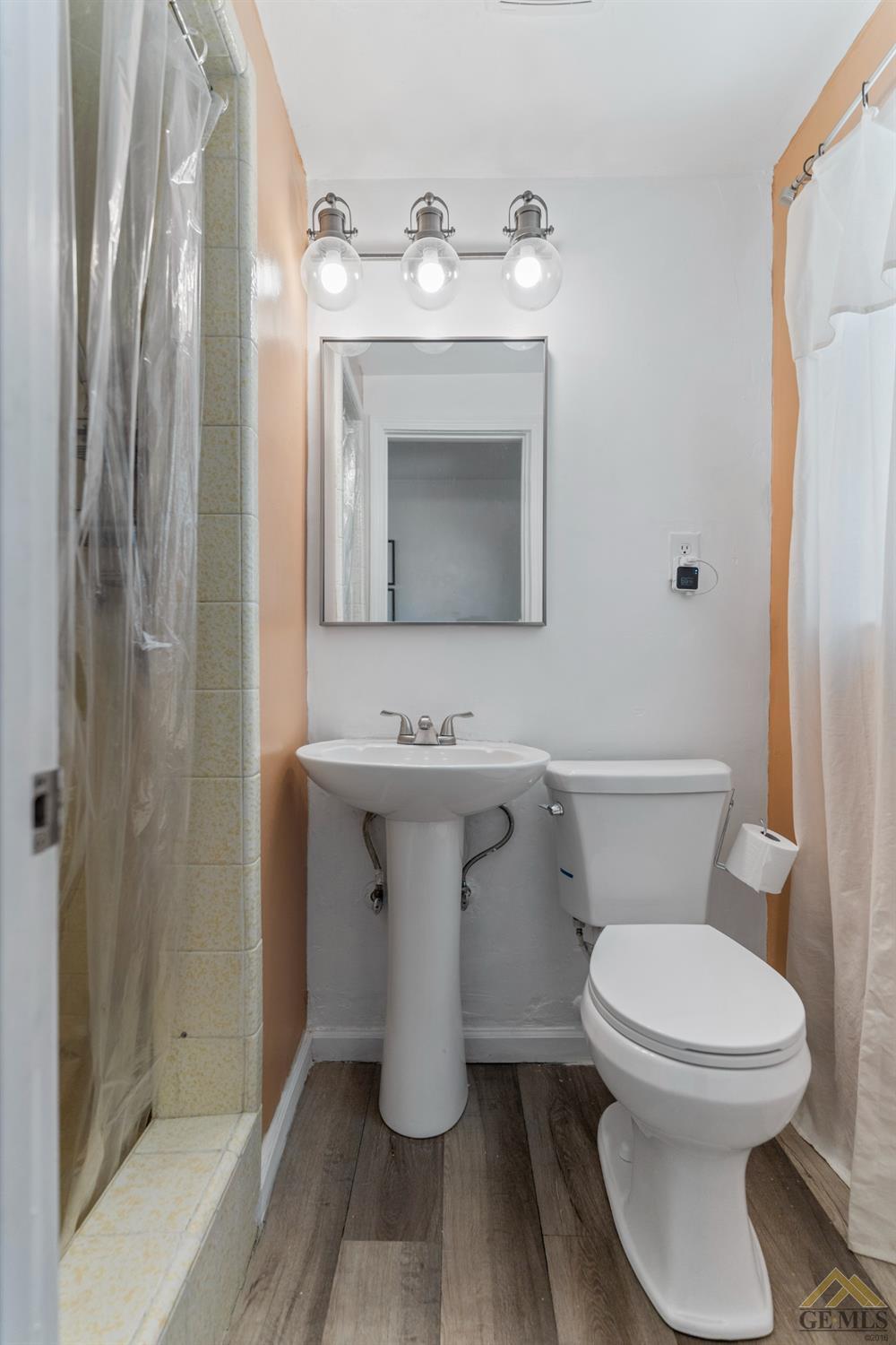 Undisclosed Address Bakersfield, CA 93305 - Photo 15 of 33 a bathroom with a toilet a sink and mirror