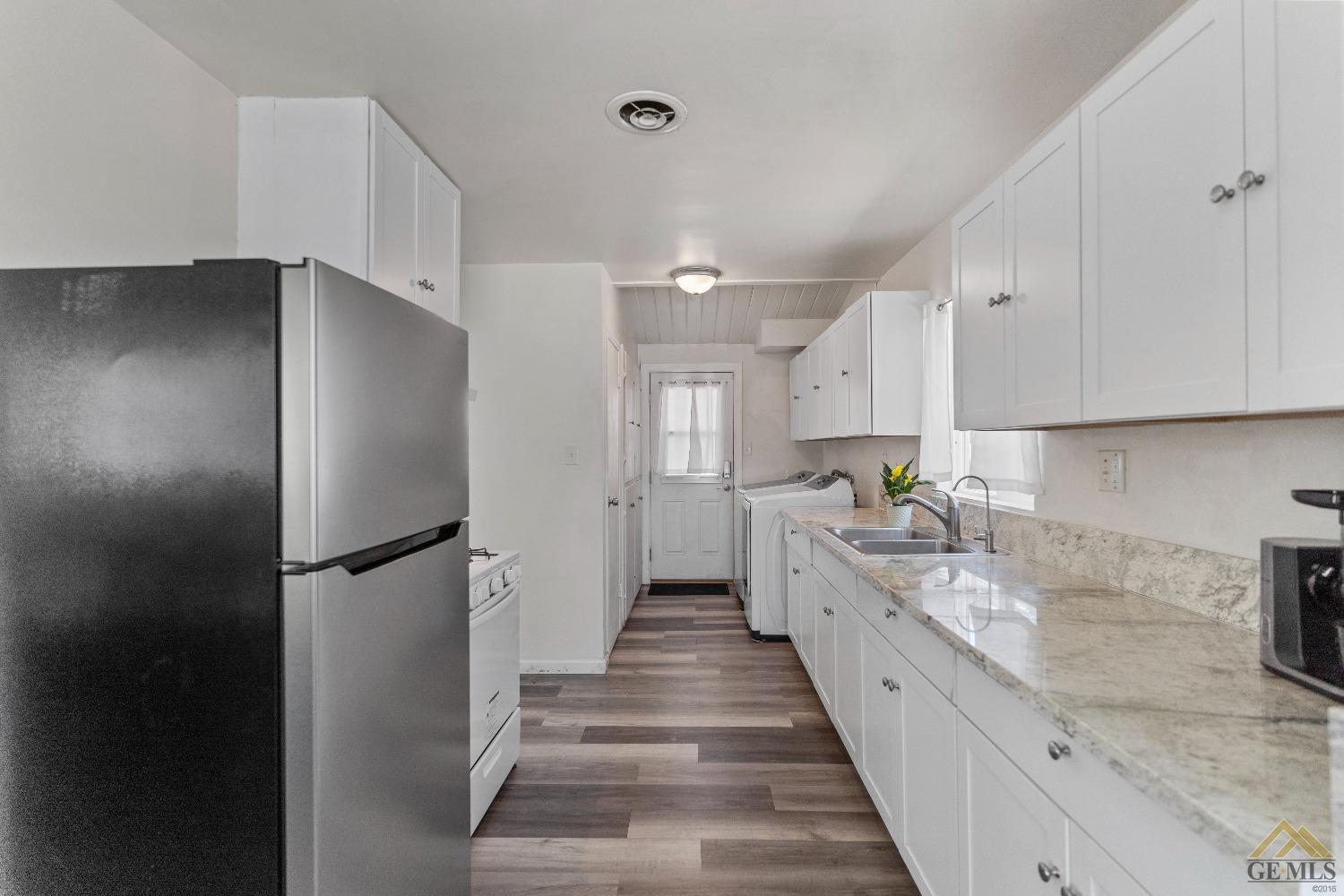 Undisclosed Address Bakersfield, CA 93305 - Photo 20 of 33 a large kitchen with a refrigerator a sink and dishwasher
