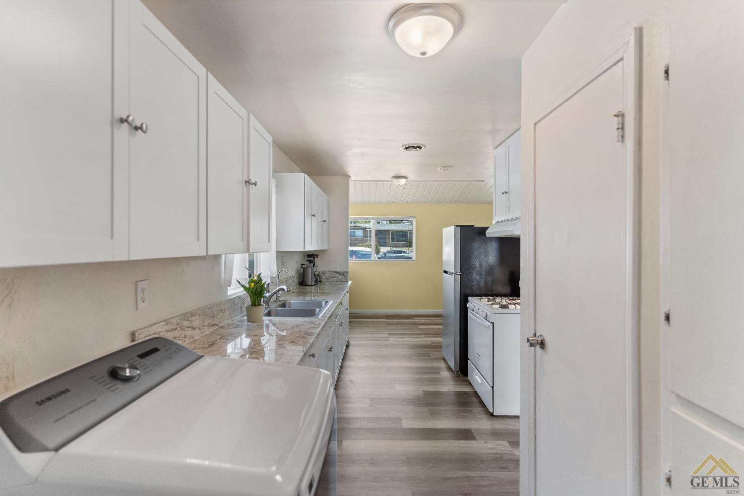 Undisclosed Address Bakersfield, CA 93305 - Photo 25 of 33 a room with stainless steel appliances a refrigerator a stove a washer dryer and white cabinets