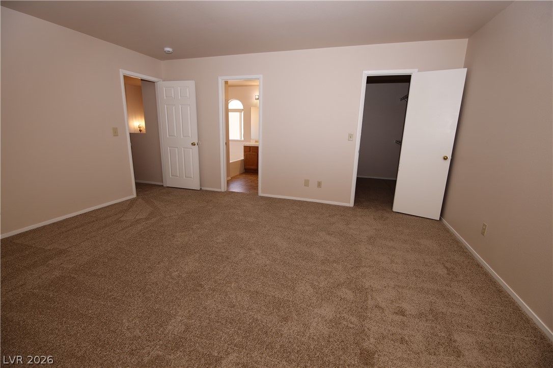 8220 Maplestar Road Las Vegas, NV 89128 - Photo 16 of 29 A spacious bedroom offers plush carpeting, two separate entryways, and ample closet space.
