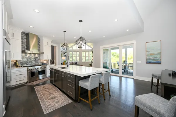 a kitchen with stainless steel appliances kitchen island granite countertop a refrigerator a stove and a sink with granite countertops