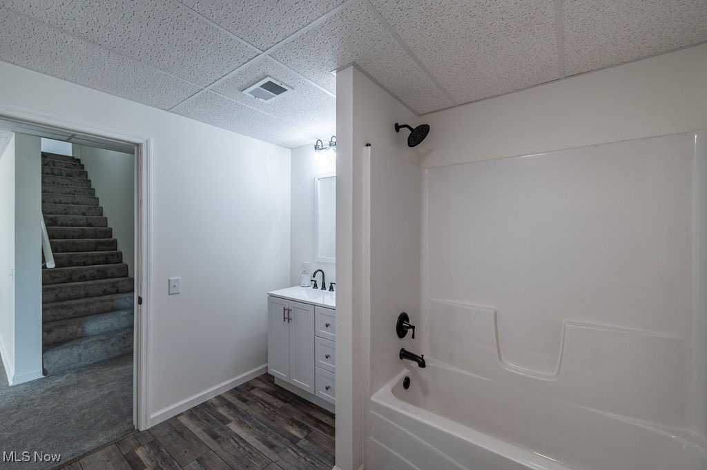 7343 Lost Pavement Road Belleville, WV 26133 - Photo 33 of 49 Full bath with tub / shower combination, vanity, dark wood-type flooring, and a paneled ceiling