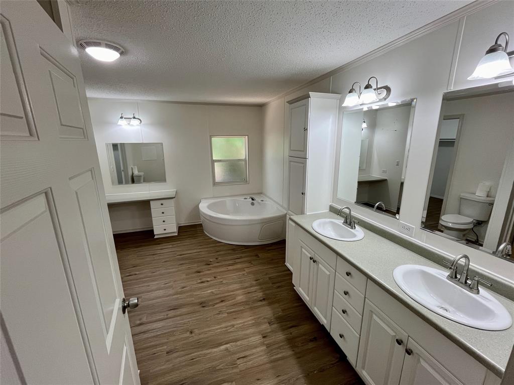 6913 Rice Road Shreveport, LA 71129 - Photo 14 of 26 a spacious bathroom with a double vanity sink a large mirror and a bathtub