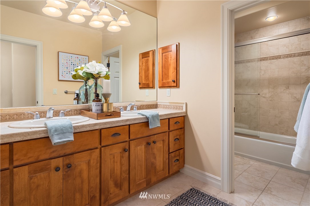 903 Belfair Road Bellevue, WA 98004 - Photo 24 of 36 a bathroom with a double vanity sink a mirror and a bathtub