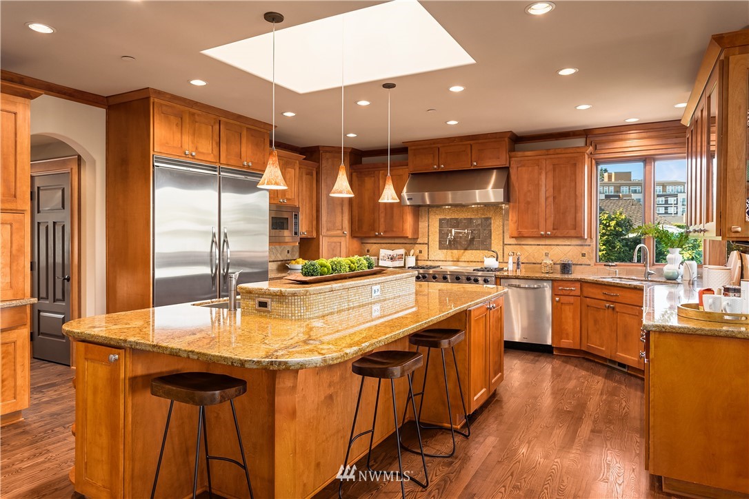 903 Belfair Road Bellevue, WA 98004 - Photo 6 of 36 a large kitchen with kitchen island a large counter top space a sink stainless steel appliances and cabinets