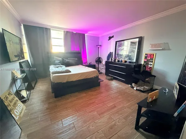 a bedroom with a bed window and a flat screen tv