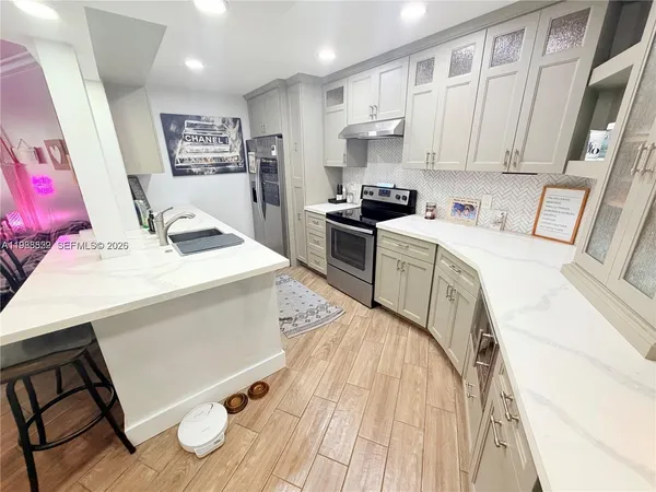 a kitchen with a sink appliances and cabinets