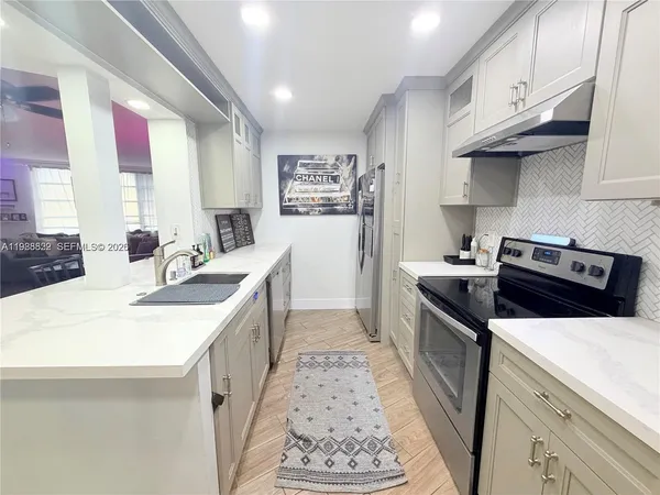 a kitchen with stainless steel appliances a sink stove and cabinets