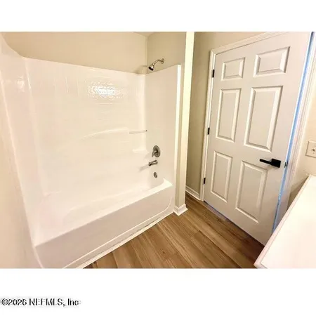 a bathroom with a tub shower and a sink