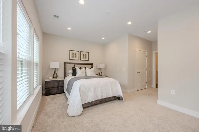 a spacious bedroom with a bed and a large window