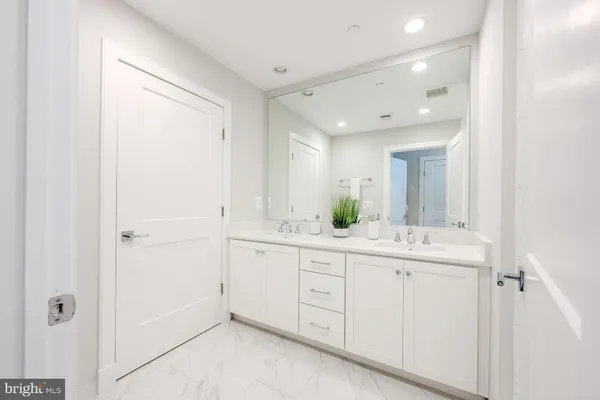 a spacious bathroom with a granite countertop sink a mirror and a