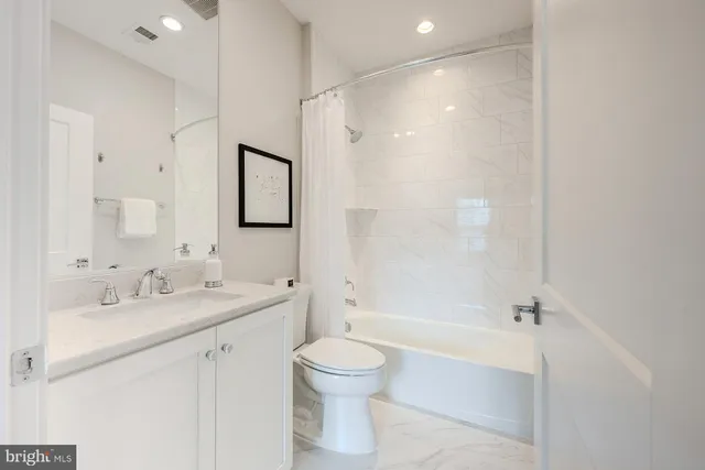a bathroom with a bathtub shower sink mirror and toilet
