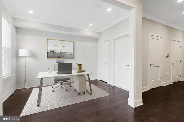 a view of staircase with lots of frames on wall and wooden floor