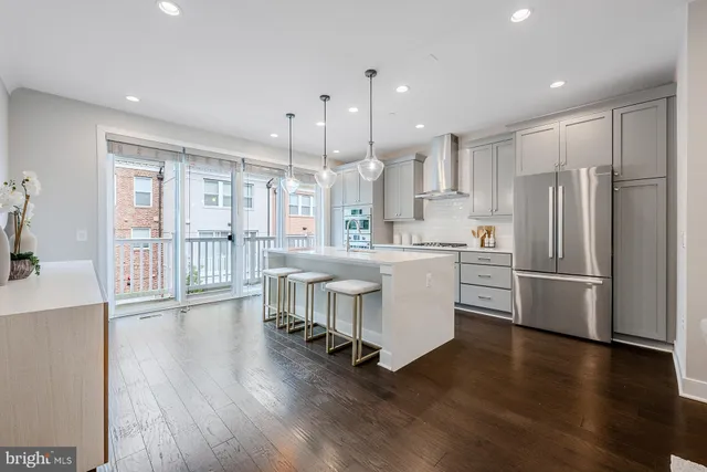 a kitchen with stainless steel appliances a refrigerator a sink appliances and a large window