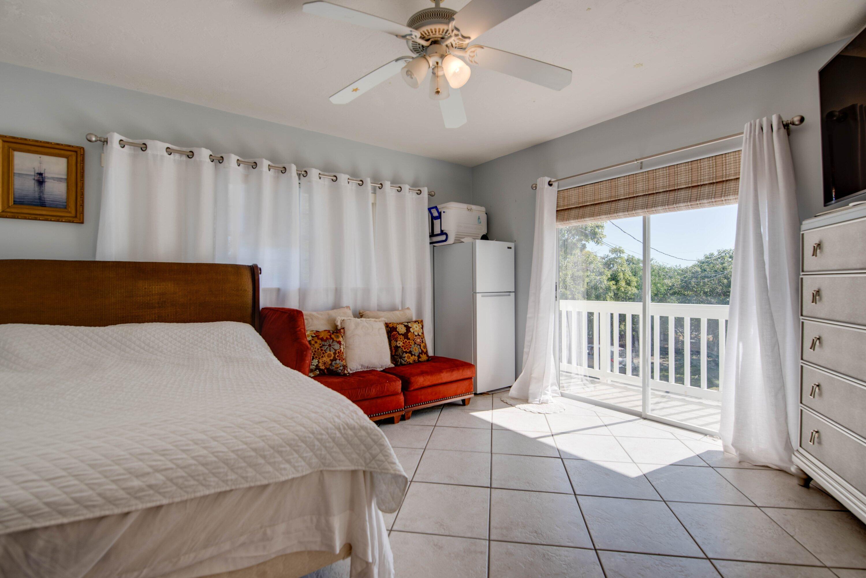 27821 Leeward S Road Summerland Key, FL 33042 - Photo 13 of 32 a bedroom with a bed and a chandelier