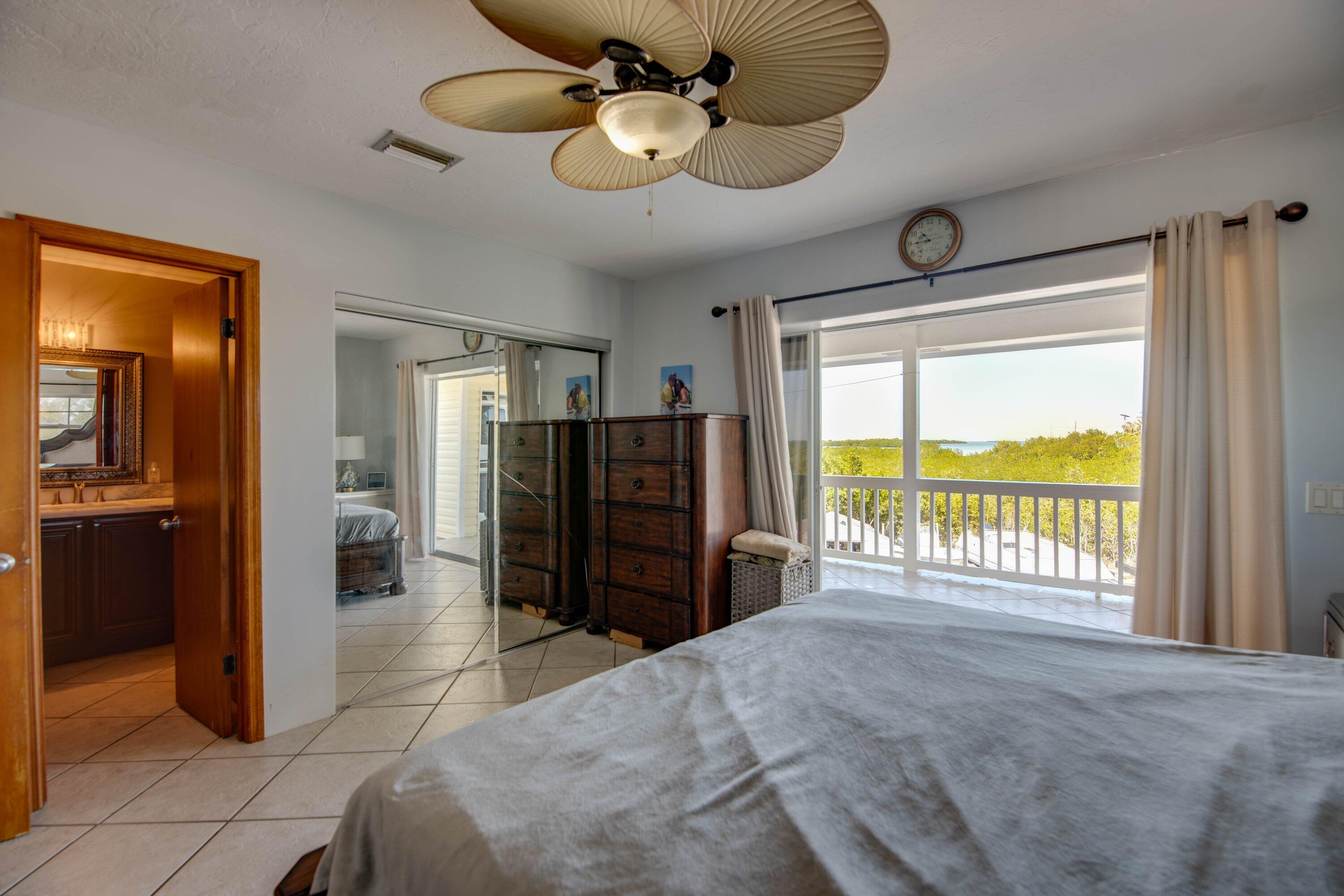 27821 Leeward S Road Summerland Key, FL 33042 - Photo 17 of 32 a bedroom with a bed and a large window