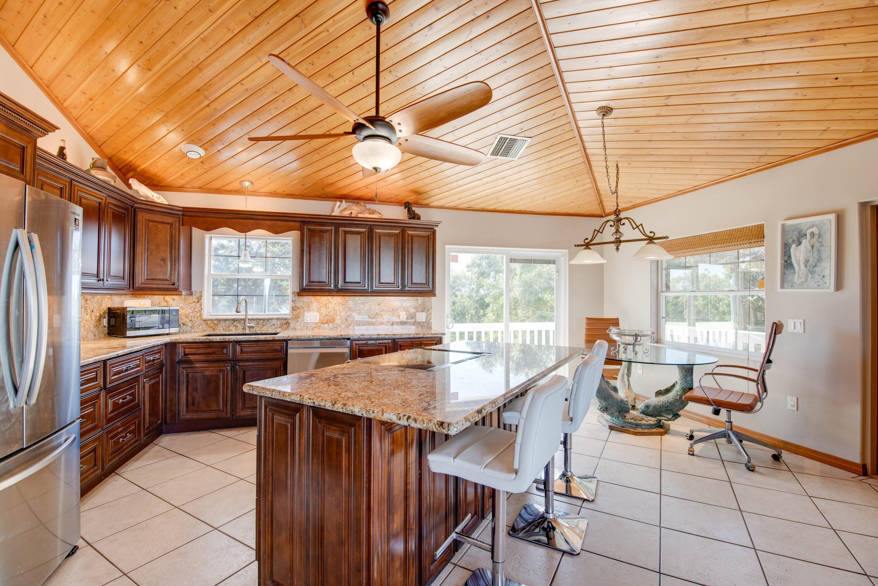 27821 Leeward S Road Summerland Key, FL 33042 - Photo 9 of 32 a kitchen with stainless steel appliances granite countertop a sink and wooden cabinets