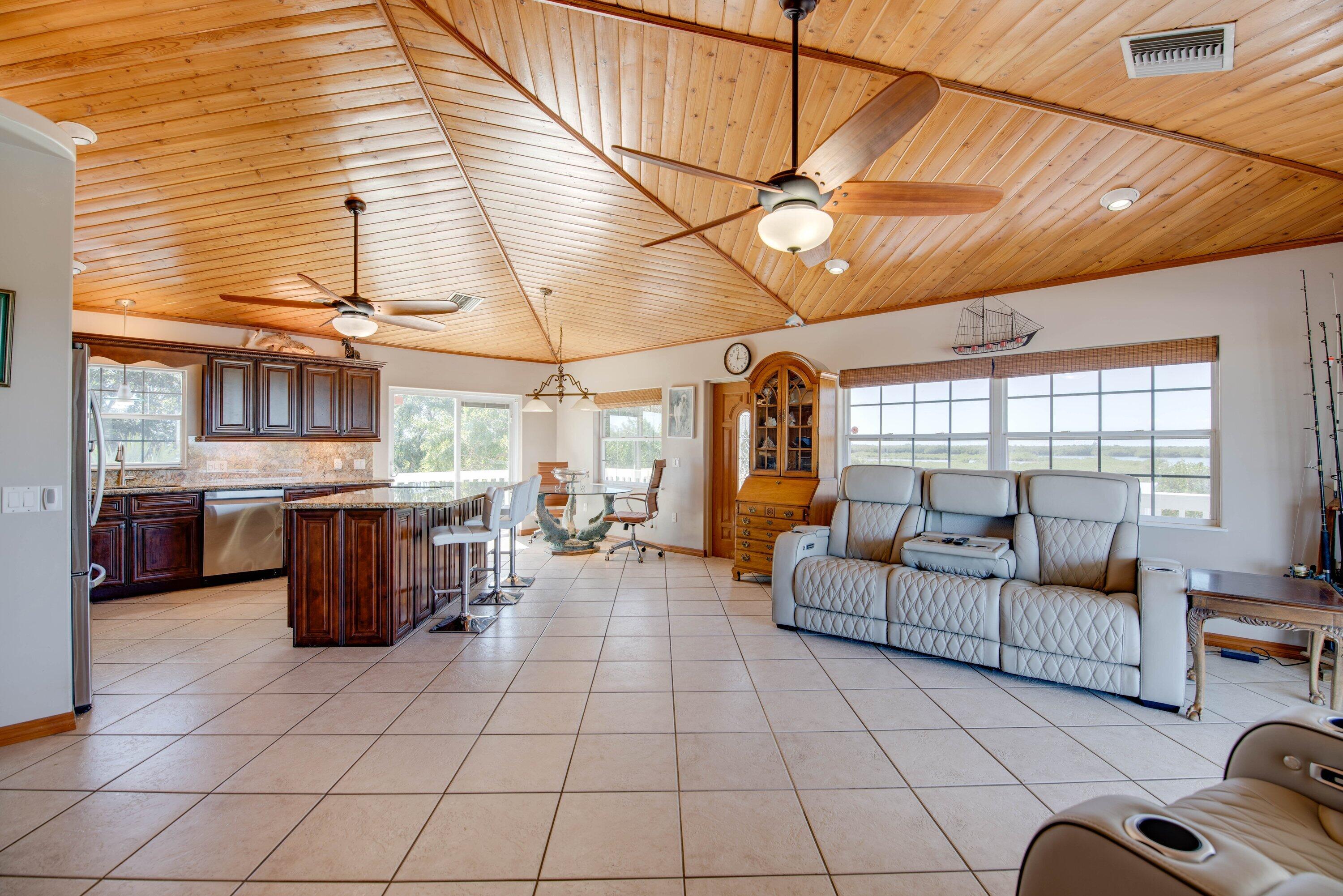 27821 Leeward S Road Summerland Key, FL 33042 - Photo 10 of 32 a living room with couches a flat screen tv and kitchen view