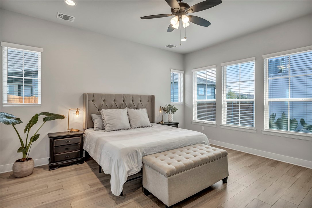 7808 Chrysler Bend Austin, TX 78744 - Photo 13 of 35 The main-level spacious primary bedroom overlooks the backyard courtyard and patio