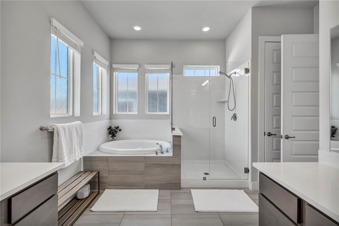 7808 Chrysler Bend Austin, TX 78744 - Photo 15 of 35 Primary bath with separate frameless shower and soaking tub. Beautiful rain glass windows allow plenty of light.