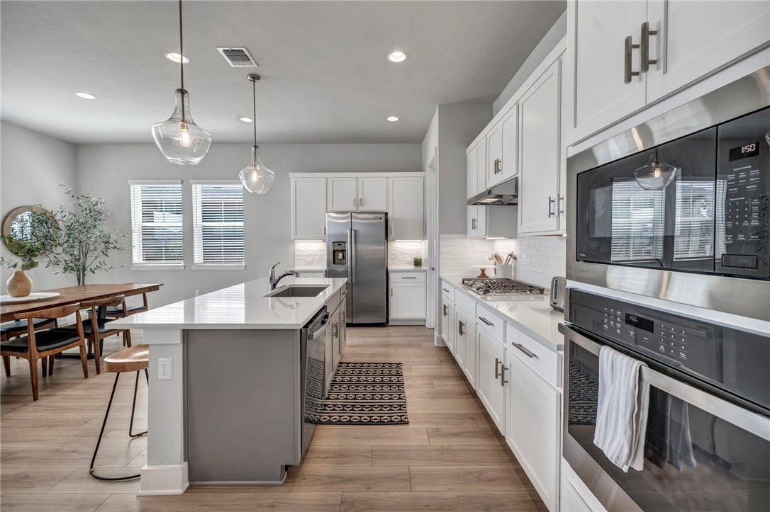 7808 Chrysler Bend Austin, TX 78744 - Photo 5 of 35 Recessed lighting, built in appliances and a black silestone sink make the kitchen space highly functional