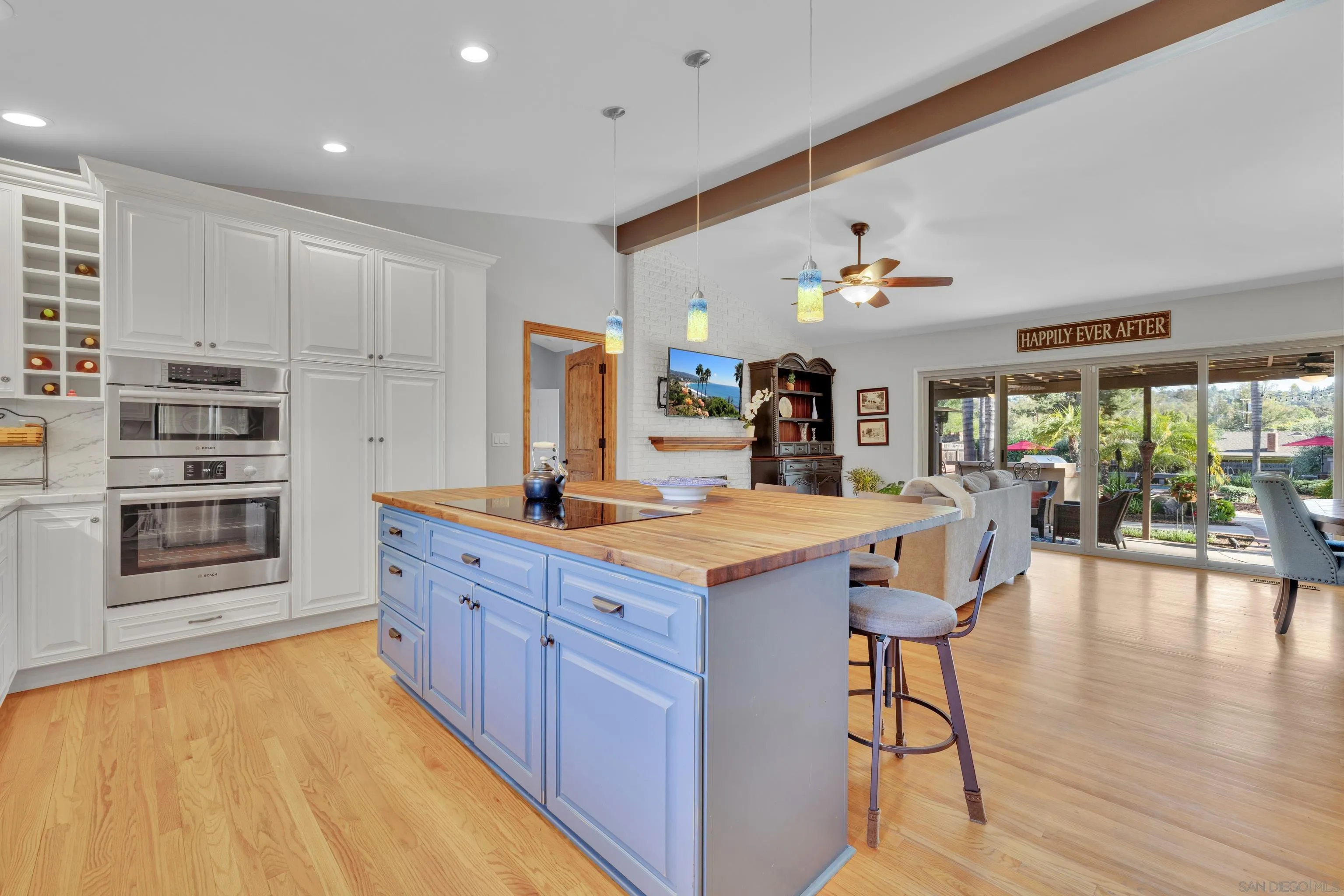 16548 Espola Road Poway, CA 92064 - Photo 11 of 70 a kitchen with stainless steel appliances granite countertop a kitchen island a stove a refrigerator a sink dishwasher with a dining table and chairs with wooden floor