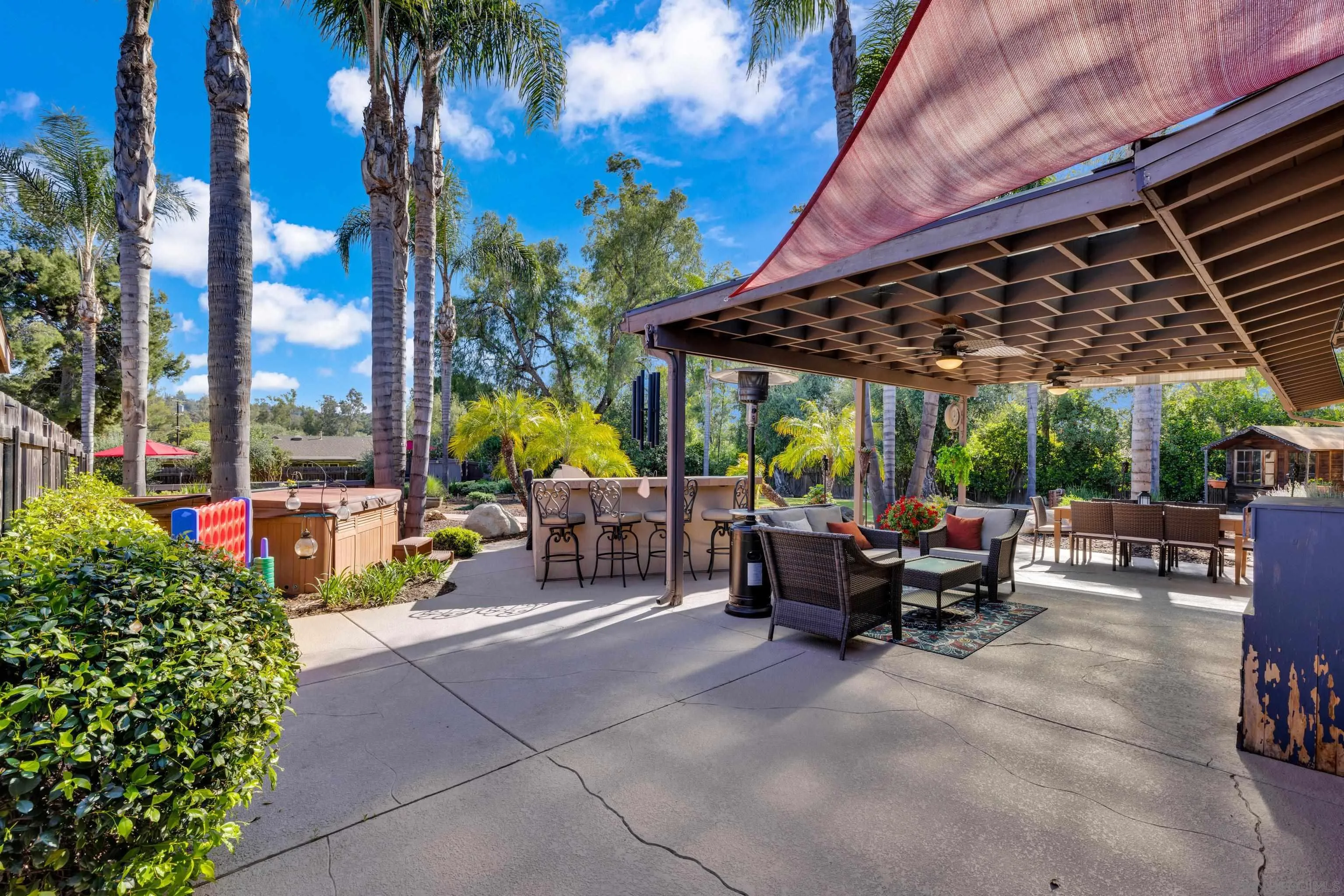 16548 Espola Road Poway, CA 92064 - Photo 46 of 70 a view of a patio with table and chairs potted plants and palm trees