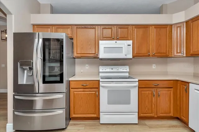 a kitchen with stainless steel appliances granite countertop a stove and a refrigerator with cabinets