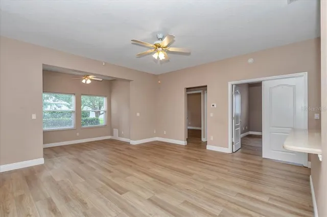 a view of an empty room with window and wooden floor