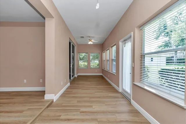 a view of a hallway with wooden floor and windows