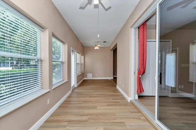a view of a hallway with wooden floor and staircase
