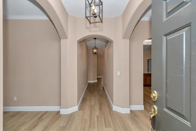 a view of a hallway with wooden floor and staircase