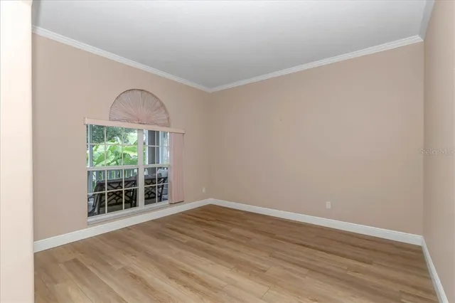 an empty room with wooden floor and a window
