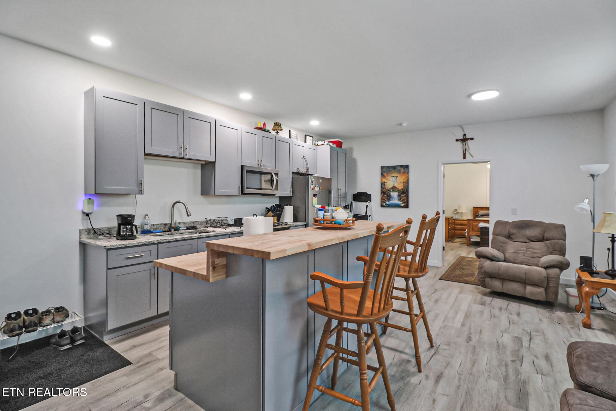 148 Porter Lane Spring City, TN 37381 - Photo 39 of 55 a kitchen with stainless steel appliances granite countertop a stove top oven a sink dishwasher a dining table and chairs with wooden floor