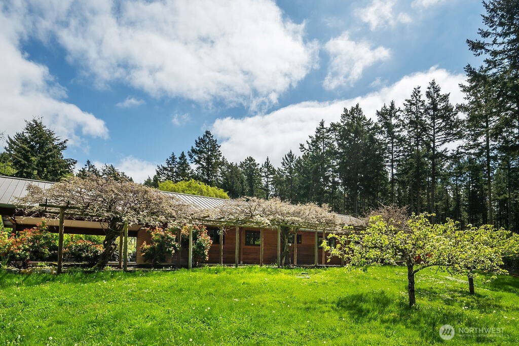 343 Burt Road Lopez Island, WA 98261 - Photo 2 of 39 a view of a house with a big yard and large trees