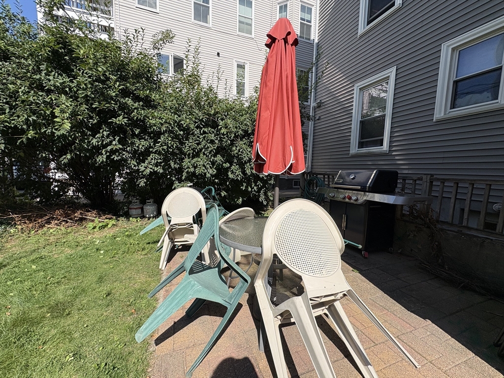 367 Cardinal Medeiros Avenue, Unit 1 Cambridge, MA 02141 - Photo 7 of 8 a backyard of a house with table and chairs