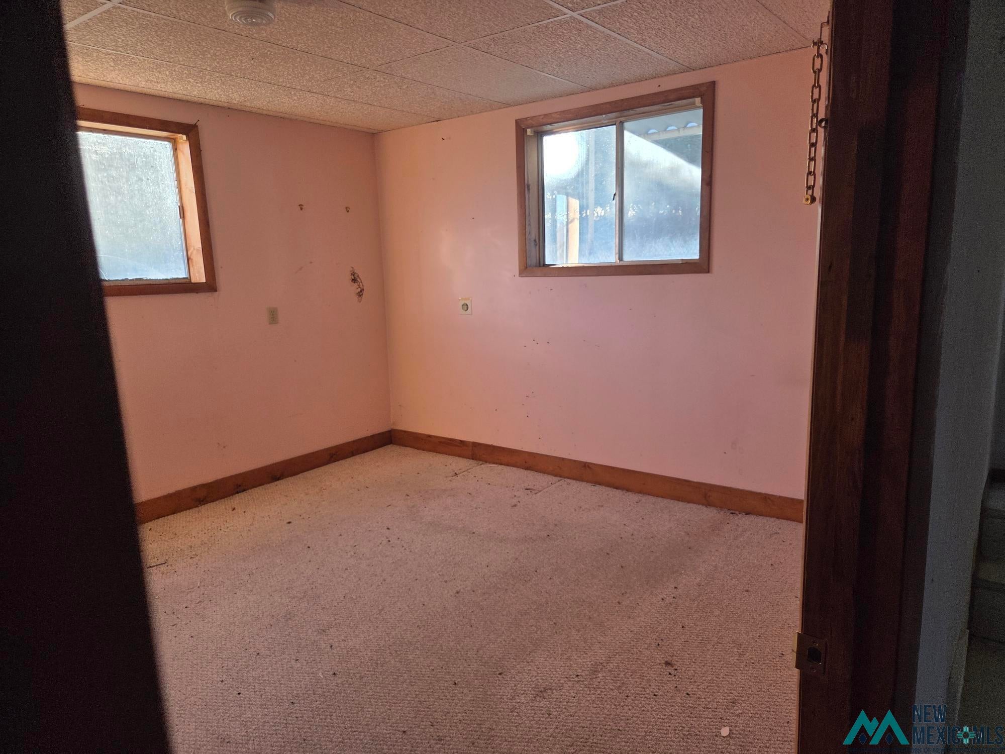 1522 Hogan Street Raton, NM 87740 - Photo 9 of 13 Unfurnished room featuring plenty of natural light and light colored carpet