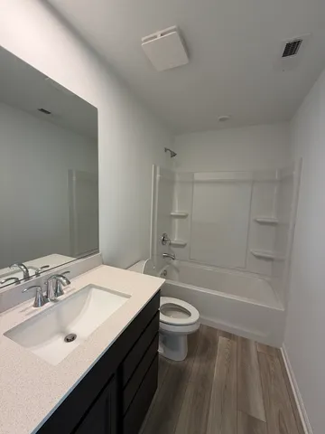 a bathroom with a sink a toilet a mirror and bathtub