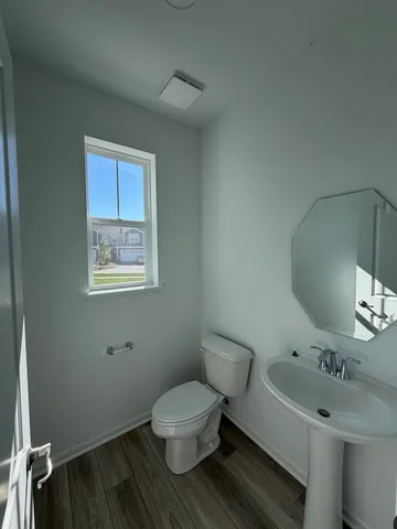 a bathroom with a toilet sink and mirror