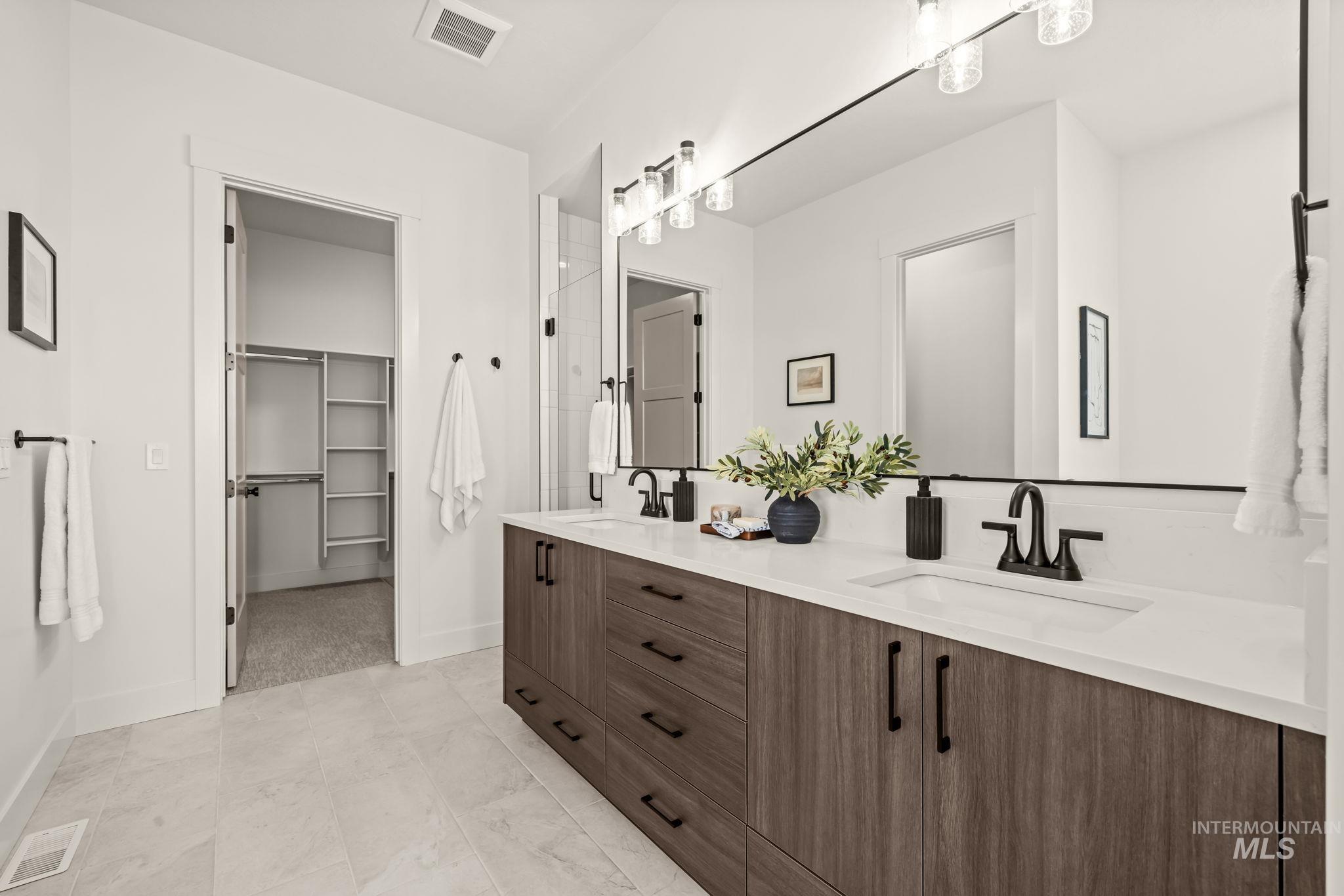 345 South Strut Way Boise, ID 83716 - Photo 28 of 50 Double vanity with undermount sinks, wood-finish cabinetry, and white countertops