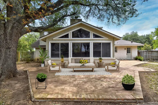 a view of a house with backyard and sitting area