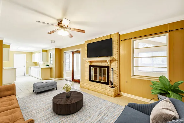 a living room with furniture a flat screen tv and a large window