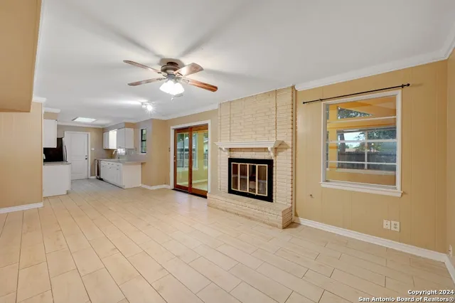 a view of an empty room with a fireplace and a window