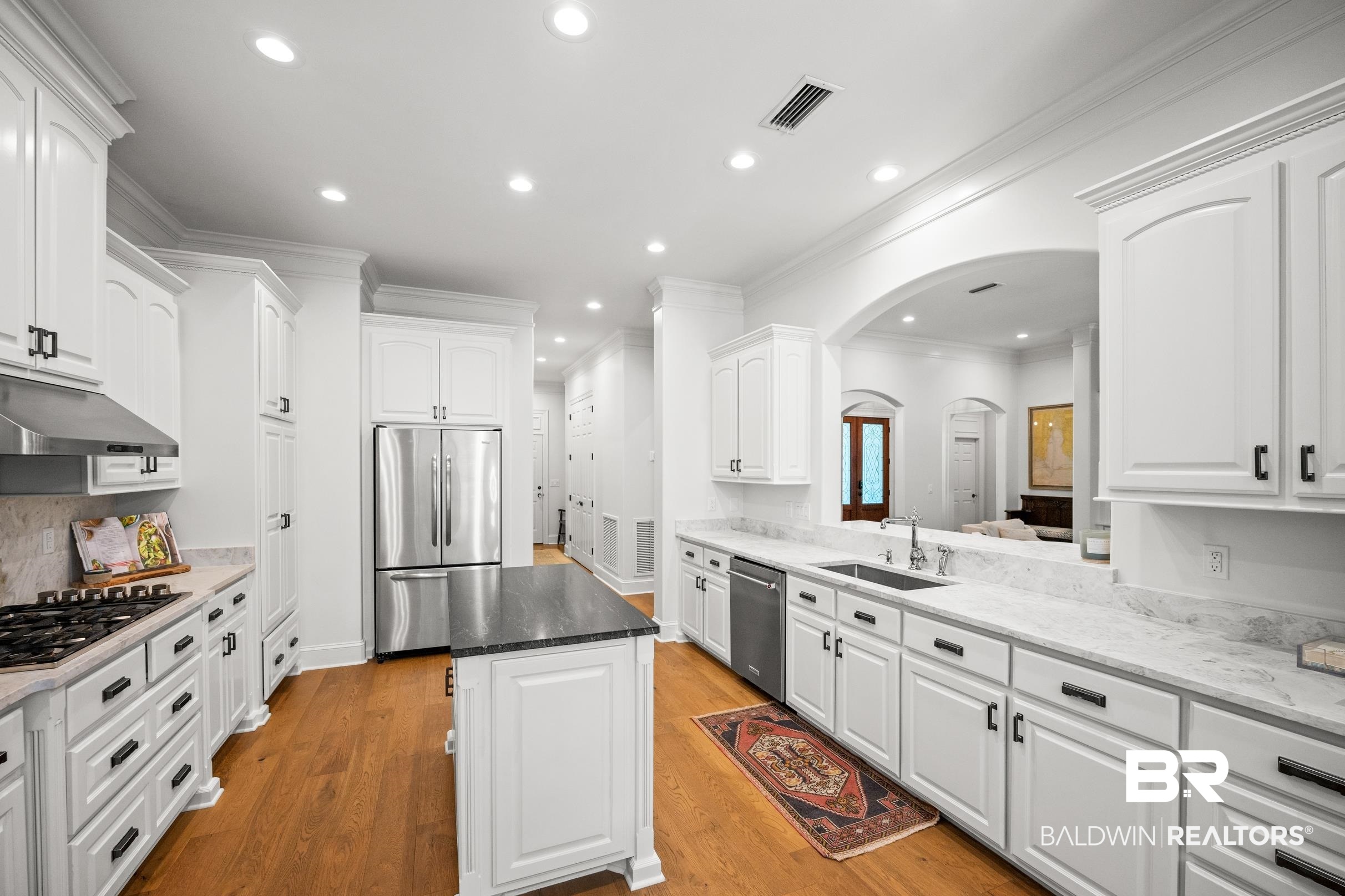 115 Sandy Ford Road Fairhope, AL 36532 - Photo 25 of 47 Kitchen featuring stainless steel appliances, arched walkways, under cabinet range hood, a kitchen island, and recessed lighting