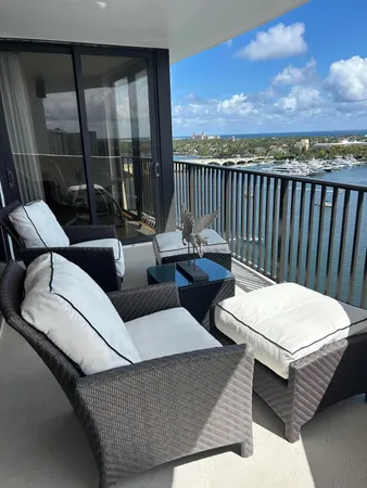 a balcony with furniture and a floor to ceiling window