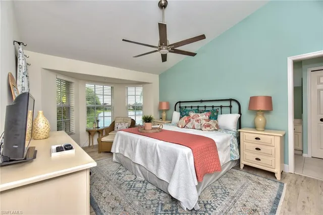 a bedroom with a bed and large windows